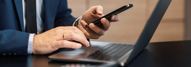 A business man with a laptop on his phone