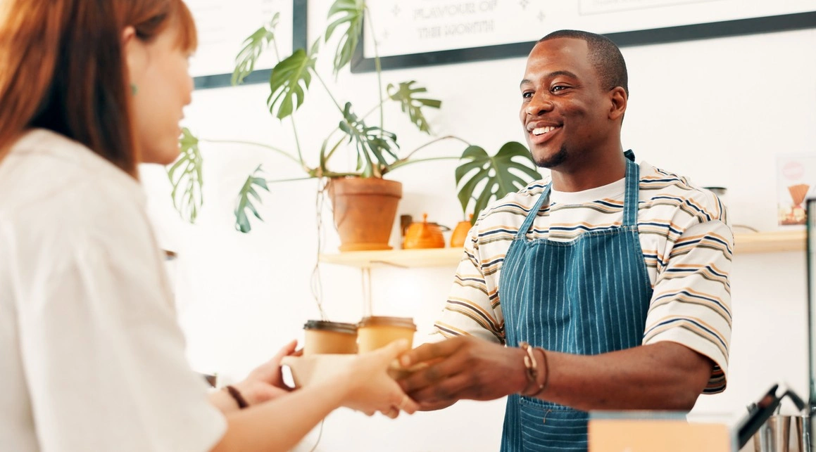 A barista serving a customer coffee