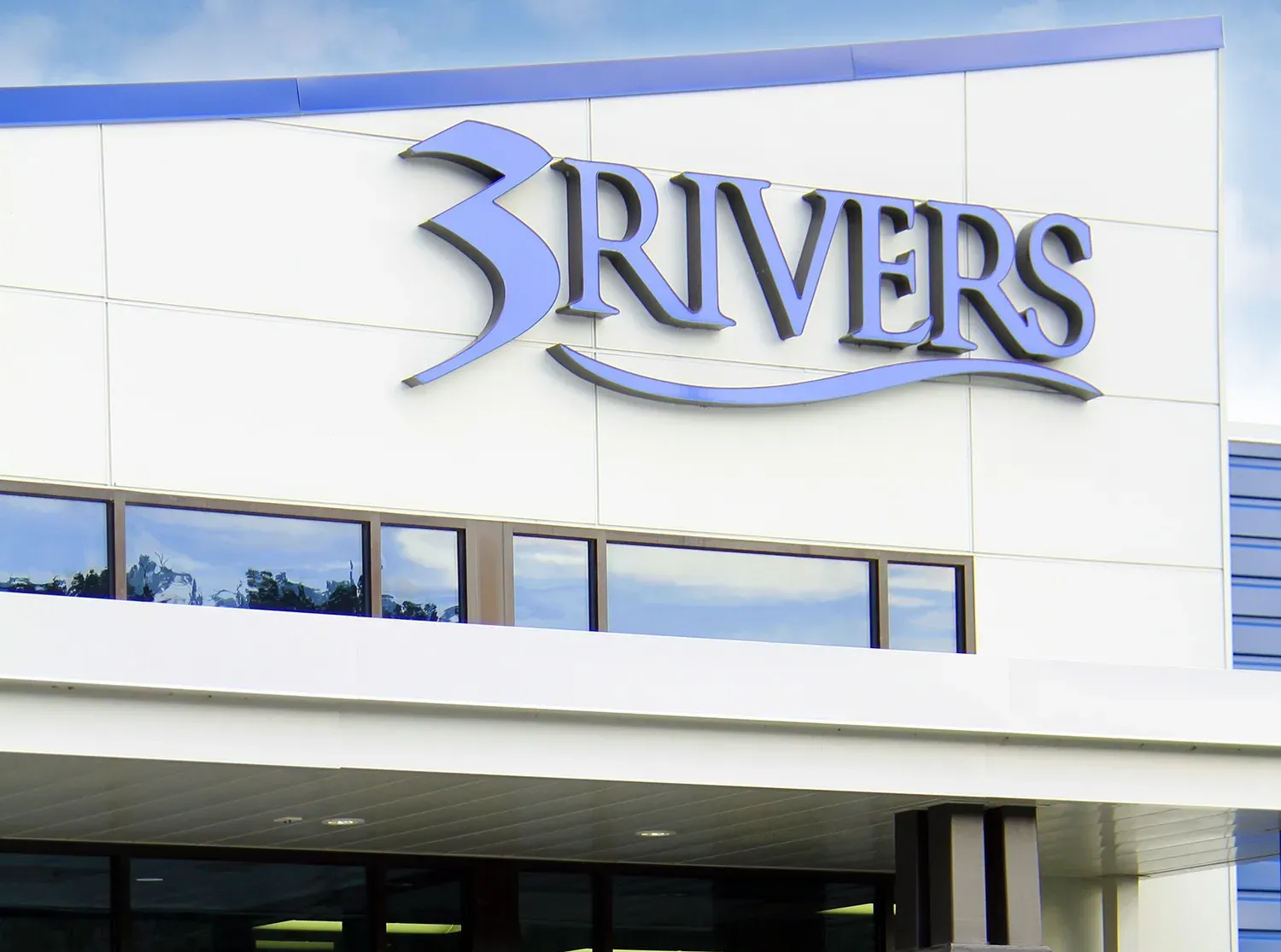 A family standing in front of a 3Rivers building