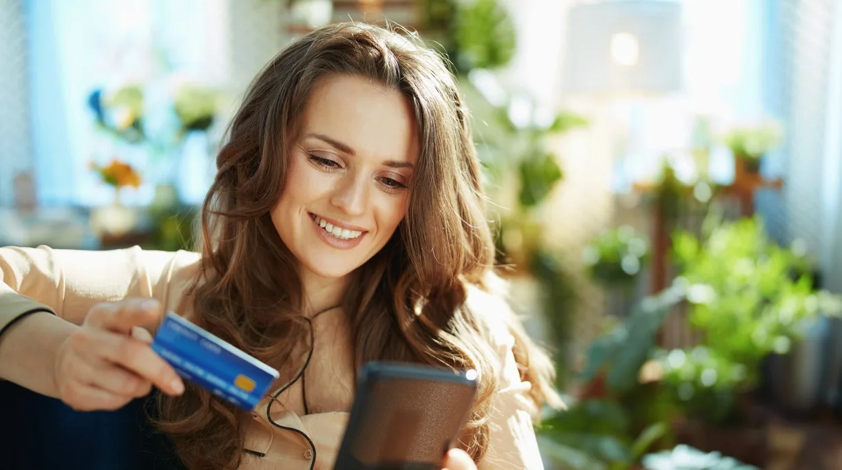 A woman entering her credit card info into her phone
